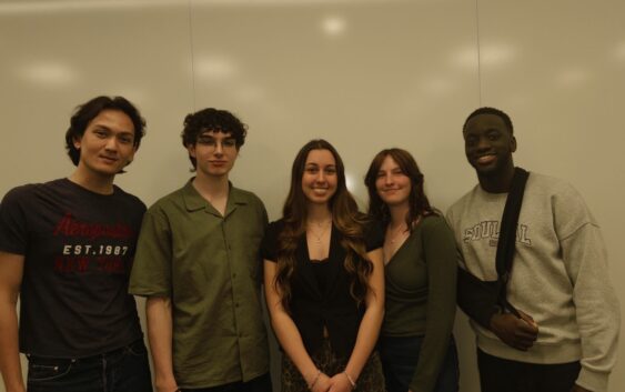 Five students smile at the camera